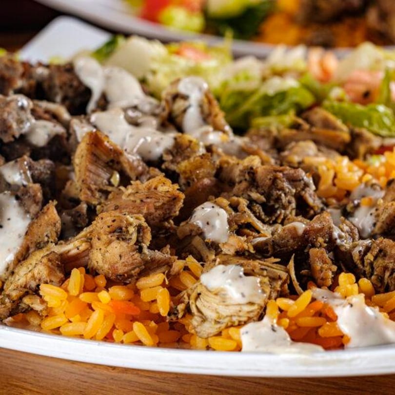 Gyro Grill's chicken and rice platter with creamy white sauce and a side salad.