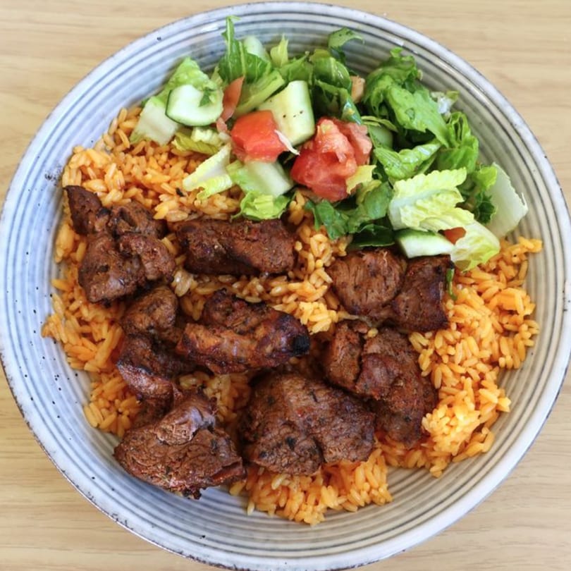 Gyro Grill's Mediterranean bowl with seasoned meat, orange rice, and a fresh salad.